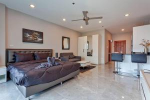 a bedroom with a large bed and a living room at Beachfront condo Phratamnak in Pattaya South