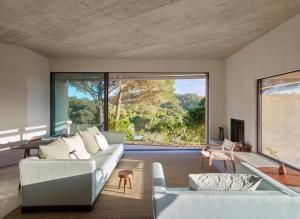 a living room with a couch and a large window at Cá na Serra in Melides