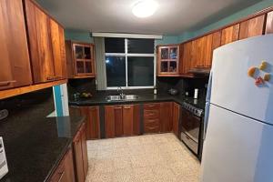 a kitchen with wooden cabinets and a white refrigerator at Beachfront apartment in Salinas Malecom in Salinas +5 photos