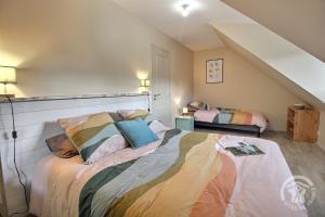 a bedroom with a large bed with colorful pillows at Ty palus in Plouha