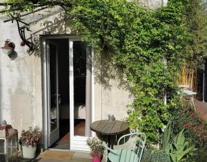 a table sitting in front of a door of a house at Chambre dans une dépendance La Rosette in Fontenay-sous-Bois