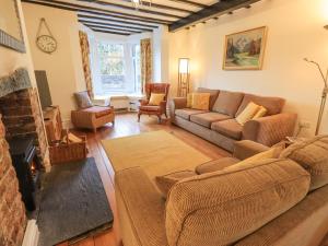 Una sala de estar con un sofá y una chimenea. en Greta Mill, en Keswick