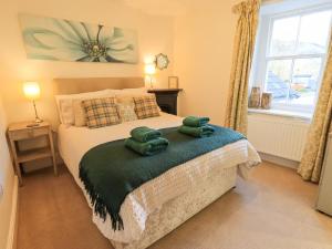 1 dormitorio con 1 cama y 2 toallas verdes en Greta Mill, en Keswick