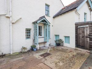 una casa blanca con una puerta azul y un patio en Greta Mill, en Keswick