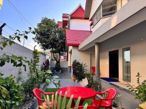 a red table and chairs in front of a house at Ariana Homestay in Siliguri