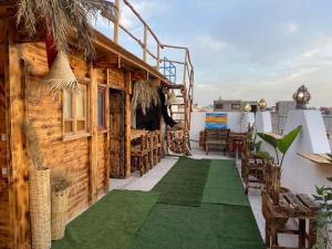 een terras met een groene vloer en een houten gebouw bij 33 Taghazout in Taghazout