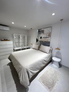 デニアにあるLalola villas - Apartamento privado Deniaの白いベッドルーム(大型ベッド1台、トイレ付)