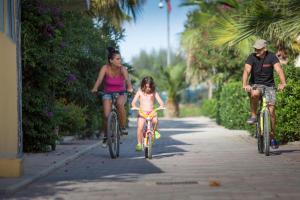 a man and a woman riding bikes with a little girl at Village Lake Placid in Silvi Marina