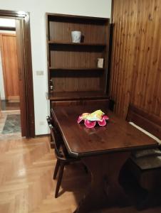 einen Holztisch mit einer rosa Blume darüber in der Unterkunft Aleksander ski apartment in Breuil-Cervinia + 12 Fotos