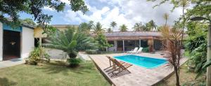a house with a swimming pool in the yard at Pousada Siriba in Caravelas