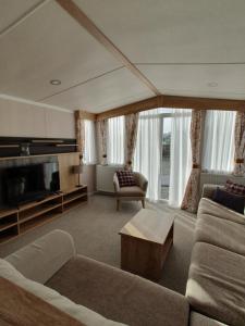 a living room with a couch and a tv at Lochgilphead Caravan Park in Lochgilphead
