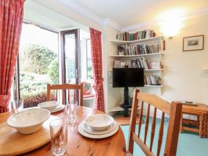 a dining room with a wooden table and a window at Swallowdale in Ambleside