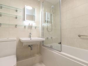 a white bathroom with a sink and a shower at Swallowdale in Ambleside +11 photos