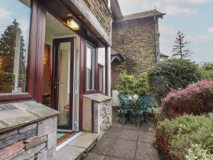 a patio with a table and chairs outside of a house at Swallowdale in Ambleside