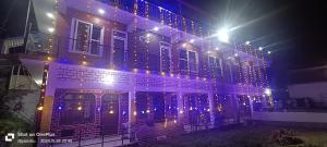 a building with christmas lights on it at night at Hotel Mansarovar in Pāndukeshwar +13 photos
