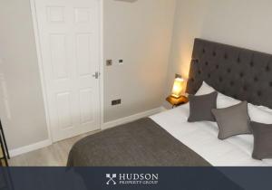 1 dormitorio con 1 cama grande y puerta blanca en Serviced Apartment with Parking, en Telford