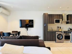 a living room with a couch and a kitchen at Just Nice Stays @ The Gardens in Accra