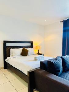 a bedroom with a large bed and a couch at Just Nice Stays @ The Gardens in Accra +11 photos