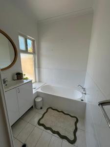 a white bathroom with a tub and a sink at Blue Holes Bungalow in Kalbarri +20 photos