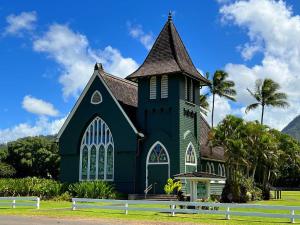 a green church with a steeple and palm trees at Anahola Beach House 6br in Anahola