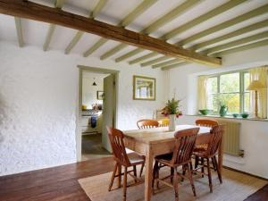 a dining room with a wooden table and chairs at Church Cottage in Bridport