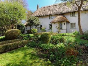 a large white house with a thatched roof at Church Cottage in Bridport