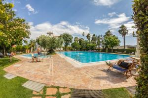 a pool at a resort with chairs and tables at Villa Irlanda Grand Hotel in Gaeta