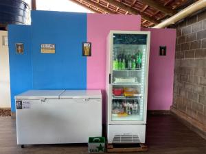 un réfrigérateur avec sa porte ouverte à côté d'un mur coloré dans l'établissement Chacara a Grande Familia, Bairro Andorinhas Otima Nova, à Uberlândia