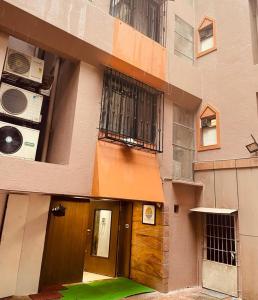 a building with a wooden door and a balcony at TIM Service Apartment Goregaon East Near NESCO in Mumbai