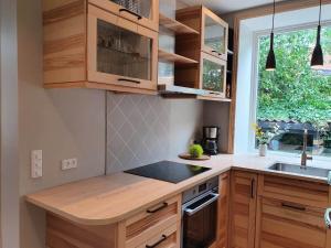 a kitchen with wooden cabinets and a sink and a window at Well Design apartment in Rønne in Rønne