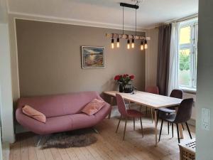 a living room with a pink couch and a table at Well Design apartment in Rønne in Rønne
