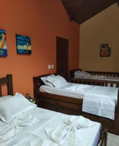 two beds in a room with orange walls at Makitub in Boracéia +56 photos