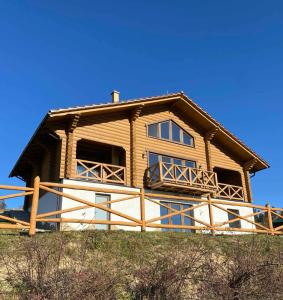 a large wooden house on top of a hill at Monte Vista 2 in Rostoka