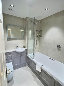 a bathroom with a tub and a sink and a shower at Three Shires Inn in Little Langdale +33 photos