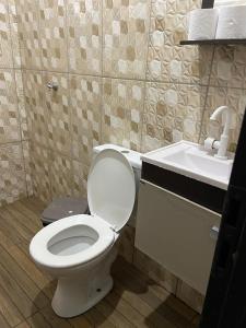 a bathroom with a white toilet and a sink at Casa maria flor in Sao Jorge