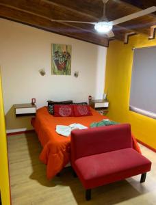 a bedroom with a red bed and a red chair at Alquiler por día en MALARGÜE muy céntrico in Malargüe