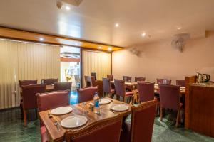 a restaurant with tables and chairs in a room at Uddhav Vilas A Family Hotel in Udaipur
