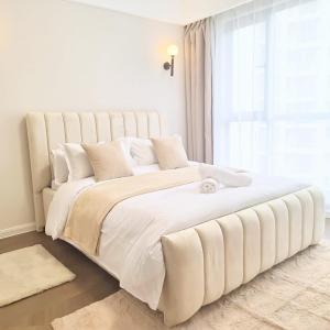 a large white bed in a white room with a window at Apple Tree Apartment , 2 bedroom Luxury suites in Syokimau