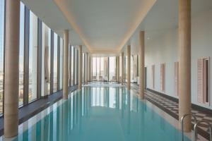 a swimming pool in the middle of a building with windows at ARK Canary Wharf in London