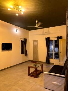 Una sala de estar con un sofá y un televisor en VILLA RISHAAM with swimming pool, en Pondicherry