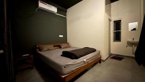 Un dormitorio con una cama con una pared verde. en VILLA RISHAAM with swimming pool, en Pondicherry 4 fotos más