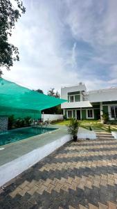Un edificio con un toldo verde y una piscina. en VILLA RISHAAM with swimming pool, en Pondicherry