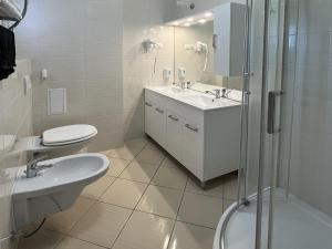 a bathroom with a toilet and a sink and a shower at Camille Apartmanhouse in Budapest