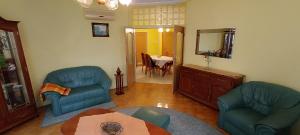 a living room with two chairs and a table at Centrum Suite in Hévíz