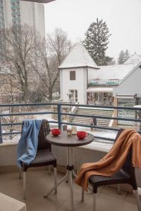 a table and chairs on a balcony with a view at Centrum Suite in Hévíz