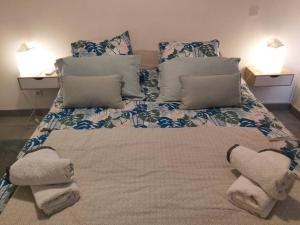 a large bed with pillows and towels on it at Appt Oceanne vue sur l'océan centre ville St Leu 5 min lagon in Saint-Leu