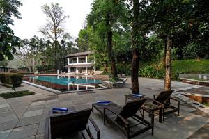 a house with a swimming pool and some chairs at Sterling Wayanad in Sultan Bathery