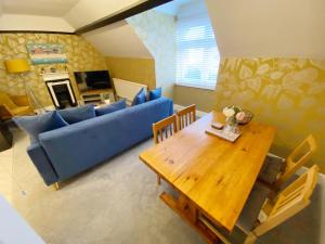 a living room with a blue couch and a table at April Lodge The Beach Hut - 1Bed Apartment Near the Beach-Parking-Couples-Friends-Professionals-Contractors in Bournemouth