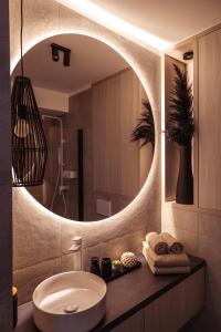 a bathroom with a sink and a large mirror at PRESTIGE ZEN Apartment & SPA by Posesja Apartamenty in Grzybowo