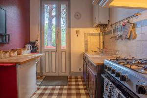 una cocina con estufa horno superior al lado de una ventana en Villa les Grillons, en Hyères 18 fotos más